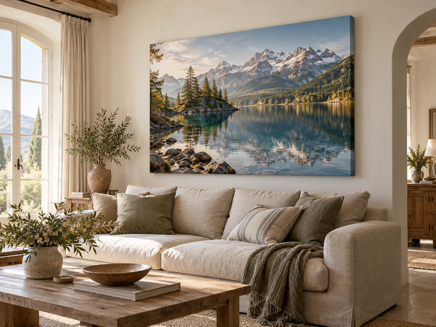 Grand tableau de lac et montagnes au-dessus d’un canapé dans un salon lumineux