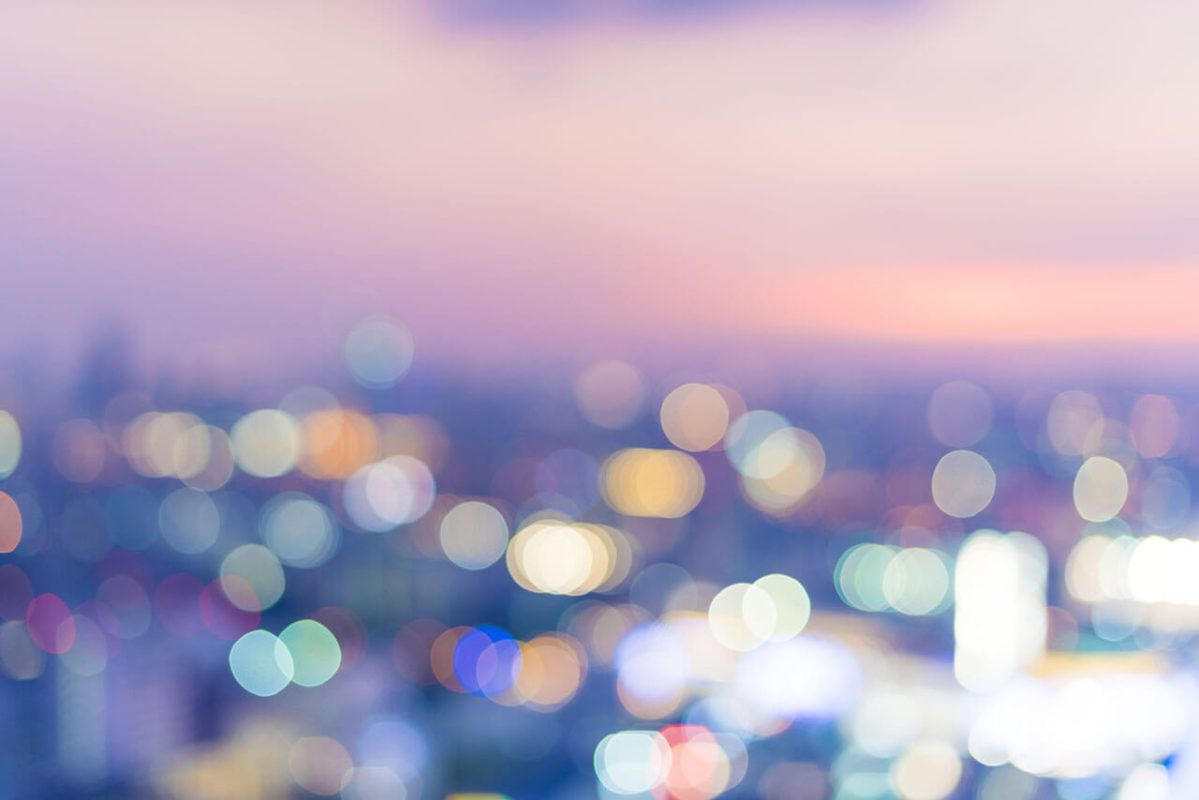 Ville au coucher de soleil avec des points lumineux flous